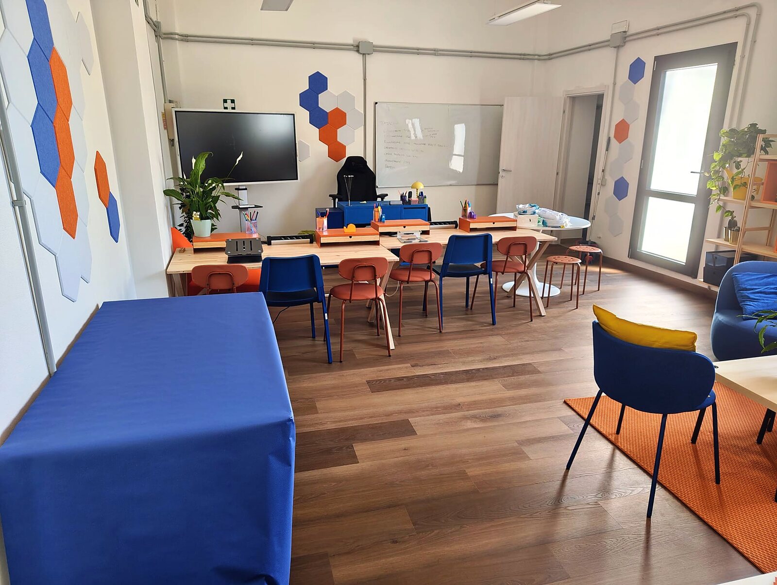 L'aula dello Spazio Binatomy coi tavoli disposti a isole e lo schermo grande
